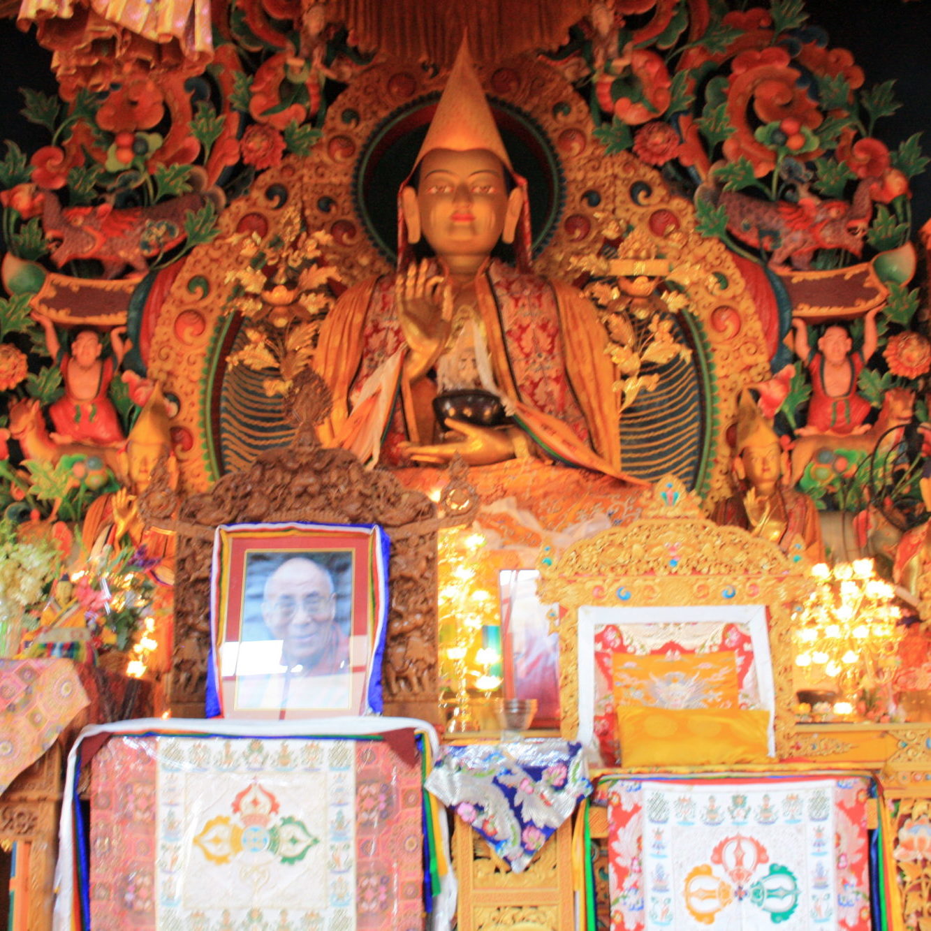 Buddha statue im Tempel mit Bild von Dalai Lama